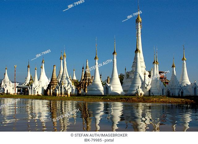 Slim stupas of Aung Min Ga Lar Paya reflect in the water Inle Lake Shan State Burma