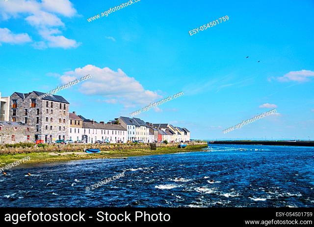 The Claddagh Galway in Galway, Ireland. People sitting at shore enjoying sunny summer day