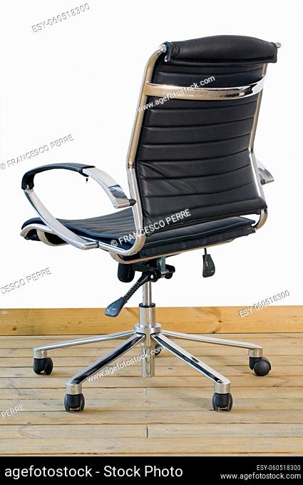 modern black leather office chair on wood floor over white background
