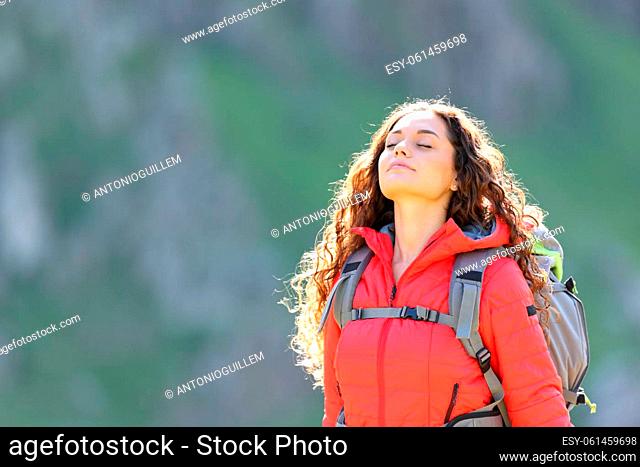 Hiker in red breathing fresh air in the mountain