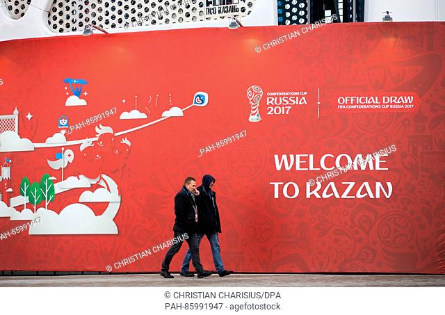 Two men walk past the entrance of the tennis academy, photographed during a rehearsal for the drawing of the groups for the Confederations Cup 2017 in Kazan