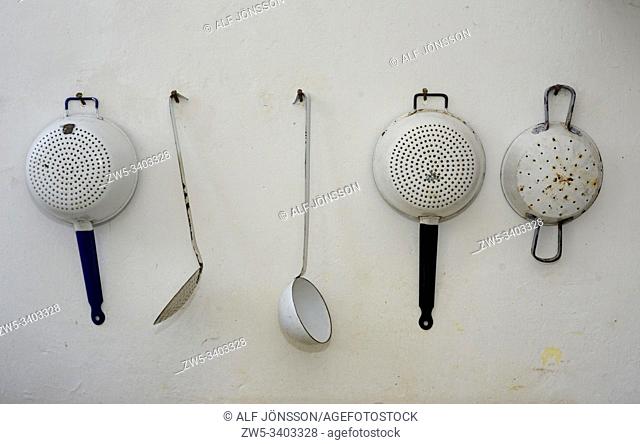 Old kitchenware hang on a wall in Statarmuséet, the museum of farmworker's home in Torup, Scania, Sweden