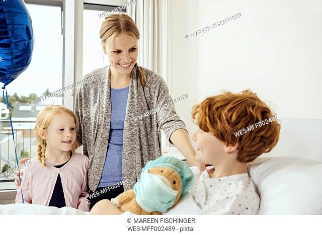 Mother and sister visiting boy in hospital at his birthday
