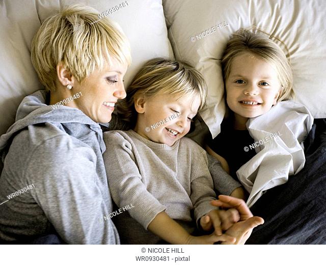 USA, Utah, Provo, Boy and girl 2-5 in bed with mother