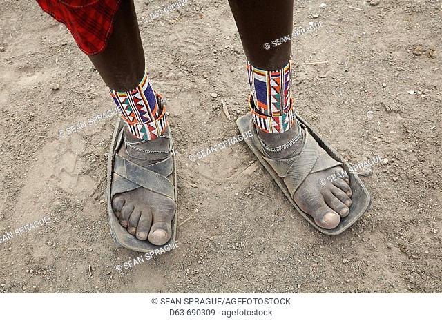 Detail of sandals made from car tires and ankle ornaments worn by a Masai warrior, Masai village within the Amboseli National Park. Kenya