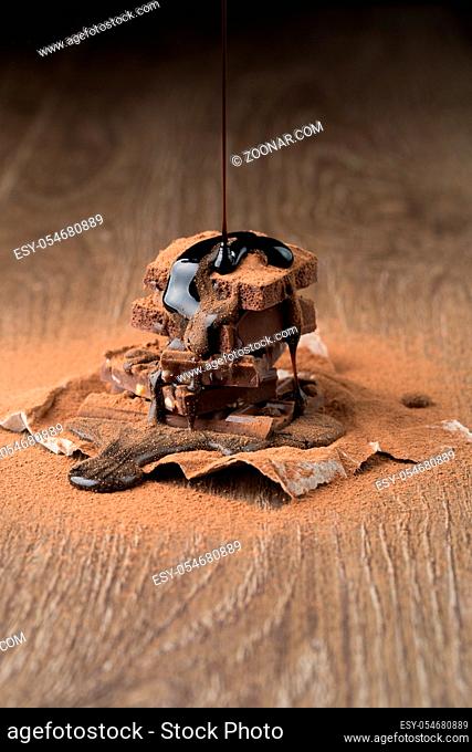 Photo of chocolate with syrup, cocoa powder at wooden table