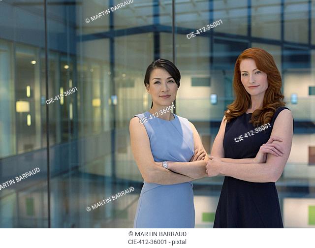 Portrait confident businesswomen in modern office atrium