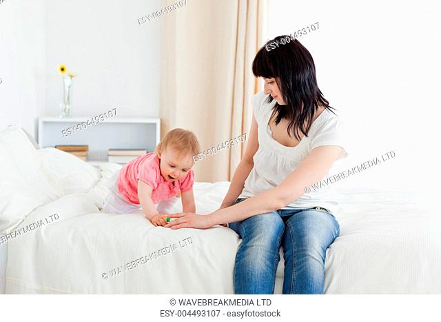 Beautiful brunette woman enjoying a moment with her baby while s