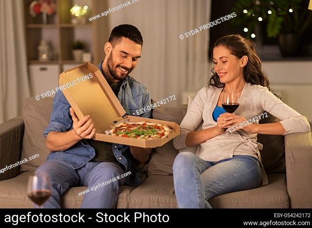 happy couple eating takeaway pizza at home