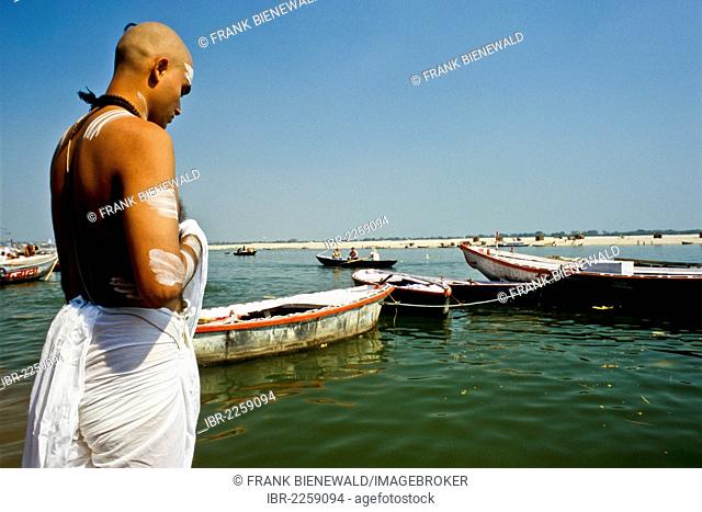 Priest praying towards the holy river Ganges, Varanasi, Uttar Pradesh, India, Asia