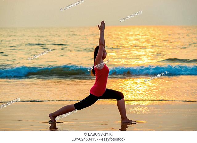 beautiful girl doing yoga near the ocean barefoot