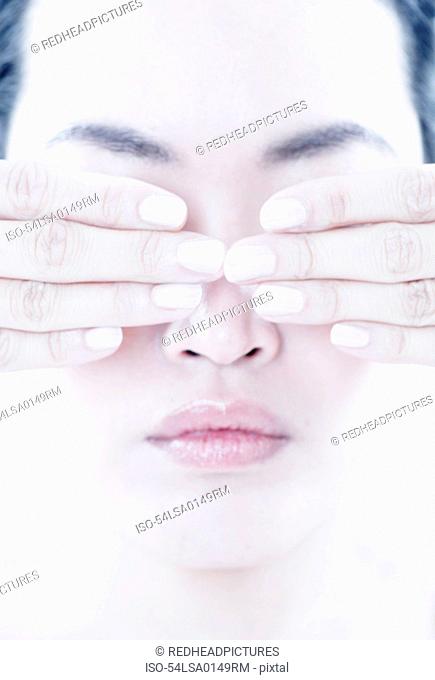 Close up of woman covering her eyes