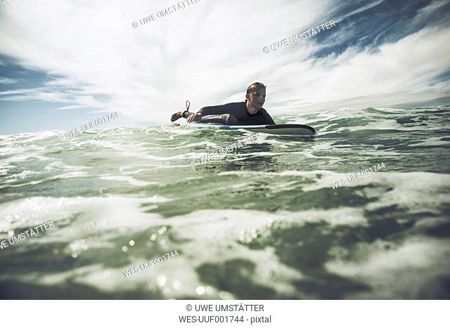France, Bretagne, Camaret sur Mer, Teenage boy surfing at Atlantic coast
