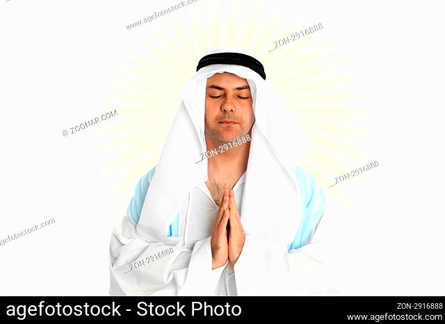 A man dressed in middle eastern or biblical clothing with hands together in prayer