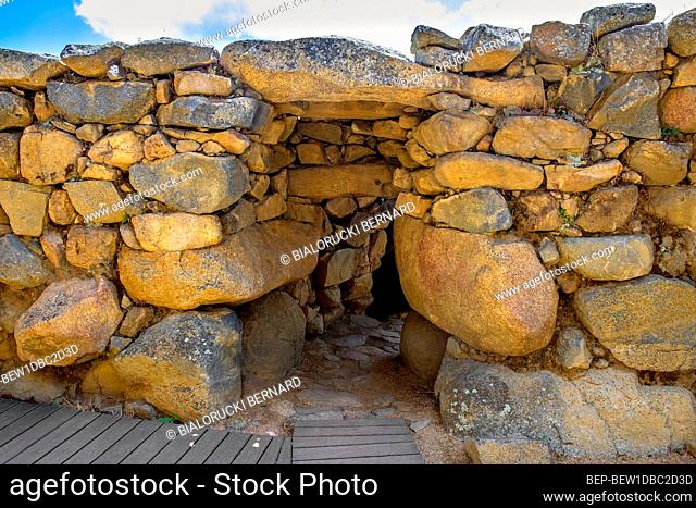 Arzachena, Sardinia / Italy - 2019/07/19: Archeological ruins of Nuragic complex La Prisgiona - Nuraghe La Prisgiona - with main entrance to stone tower of...