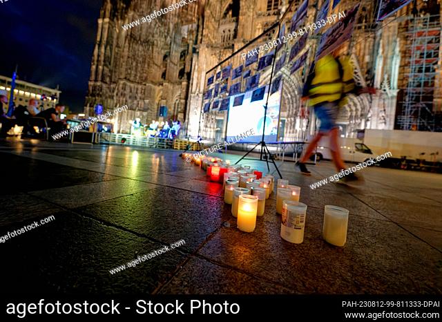 11 August 2023, North Rhine-Westphalia, Cologne: Lights in memory of victims of the war in Ukraine stand in front of the cathedral at the event ""Unbreakable...