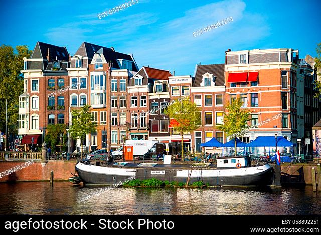 Amsterdam, Netherlands - April 19, 2017: Canal, boats and houses in Amsterdam. Amsterdam is the capital of the Netherlands in a summer day