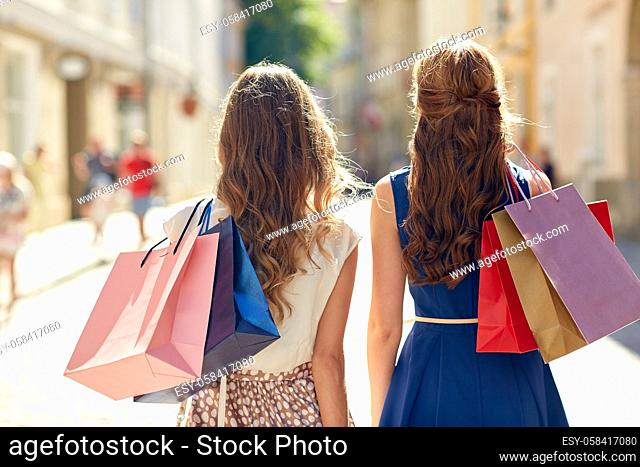 women with shopping bags walking in city
