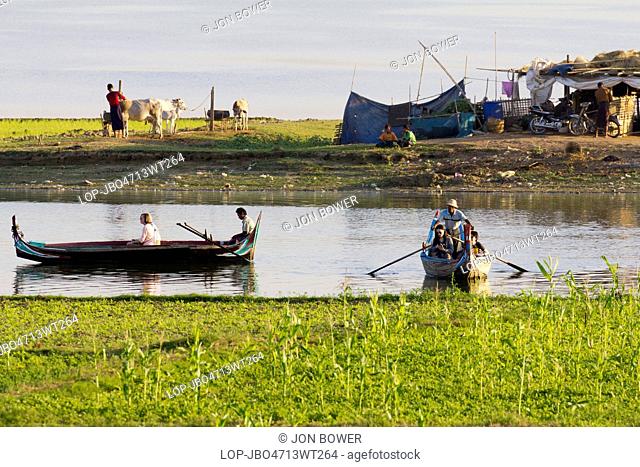 Myanmar, Mandalay, Lake Taungthaman. Tourist pleasure boats plying their trade by U Bein Teak Bridge across Taungthaman Lake in Myanmar