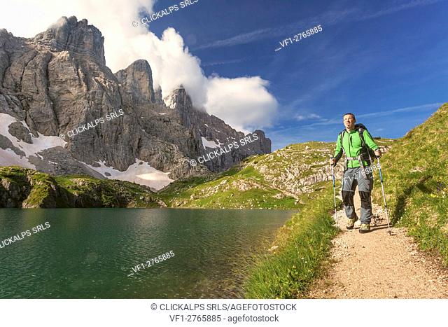 Europe, Italy, Veneto, Belluno. Hiker passes near Lake Coldai along the CAI 560, which at this point coincides with the Alta Via n. 1 of the Dolomites