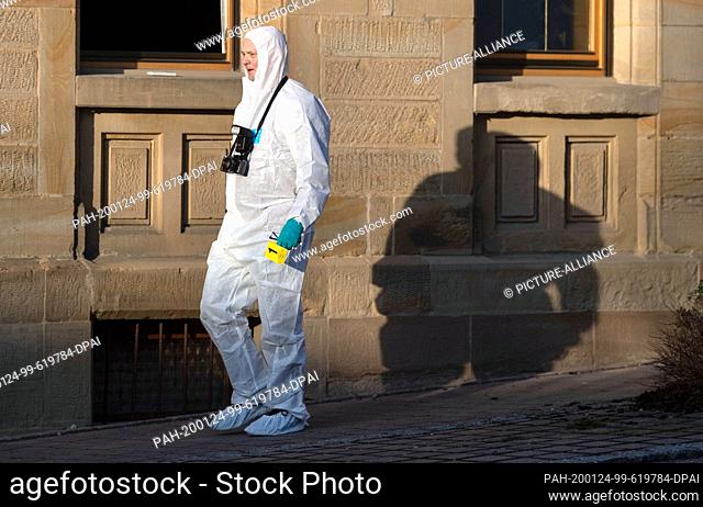 24 January 2020, Baden-Wuerttemberg, Rot am See: After shots were fired in Rot am See, a member of the forensics team walks in front of a house