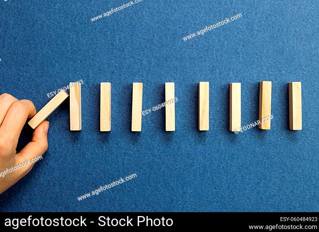 Wooden domino blocks with blue background. Domino effect business process concept