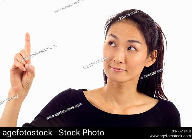 Beautiful Asian woman pointing up at copyspace isolated over white background