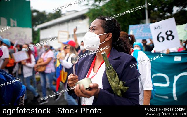 04 November 2020, Venezuela, Caracas: Healthcare workers banging on cooking pots during a protest by health and education staff in the midst of the corona...