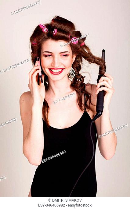 girl with hair curlers talking on the phone and makes the hairstyle 1