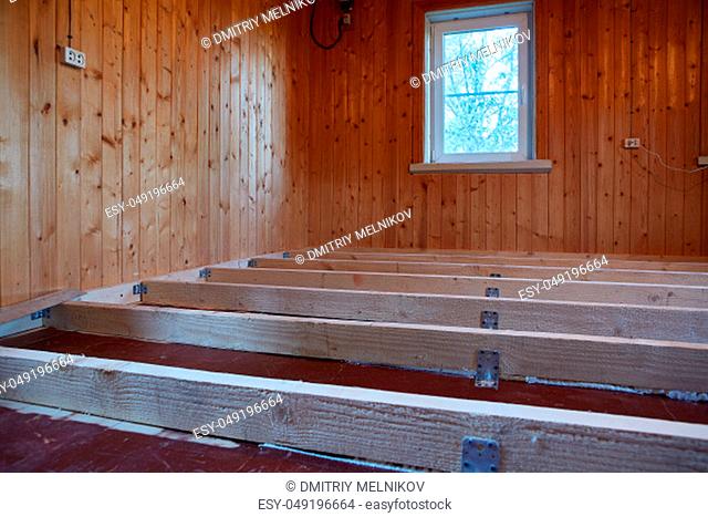 Installation of longitudinal beams for warming of a floor in the country wooden house. Stage-by-stage warming of a floor