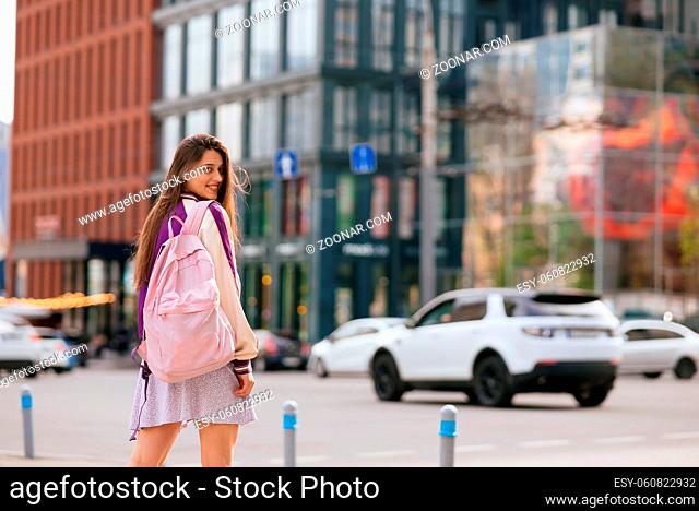 Pretty young woman, walking at the street at european city. Nice sunny day
