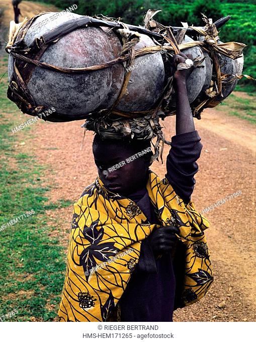 Burundi, Bujumbura Province, surroundings of Ijenda, Twa girl pygmy going to market to sell her earthenware pots