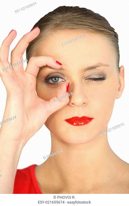 Woman making a circle with her fingers around her eye