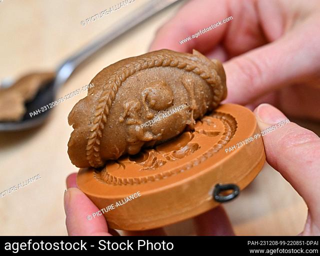 07 December 2023, Brandenburg, Frankfurt (Oder): The Viadrina Museum shows how gingerbread is made using a mold. Bake gingerbread just like 100 years ago...