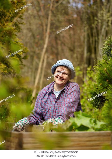 Woman weeding in the garden and she use protective gloves