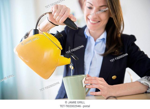 Woman making tea in office