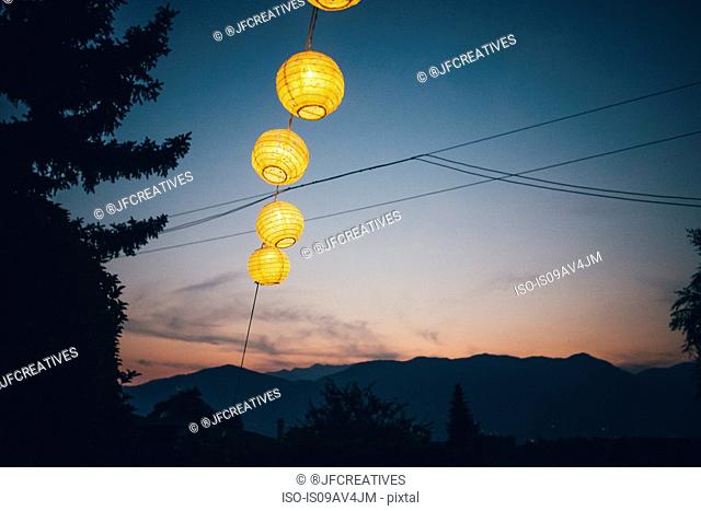 Low angle view of hanging lanterns illuminated at night, Luino, Lombardy, Italy