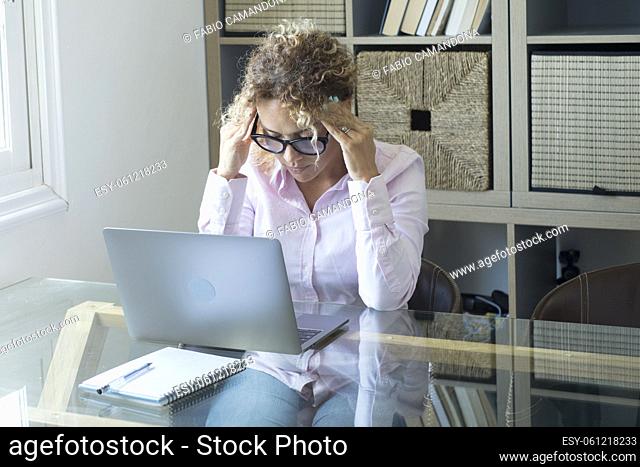 Tired and stressed people with computer job at home - concept of smart working and modern woman touching his head for thoughts and problems - unhealthy office...