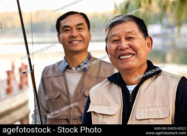 Senior friends portrait while fishing at a lake