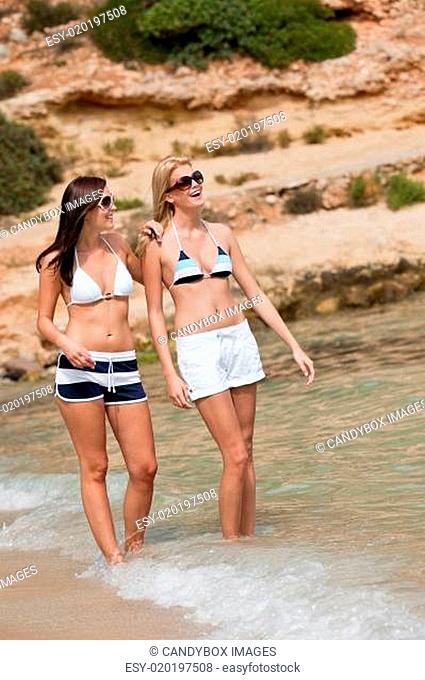 Two attractive woman in bikini on the beach