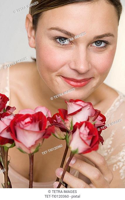 Close up of woman with stemmed roses