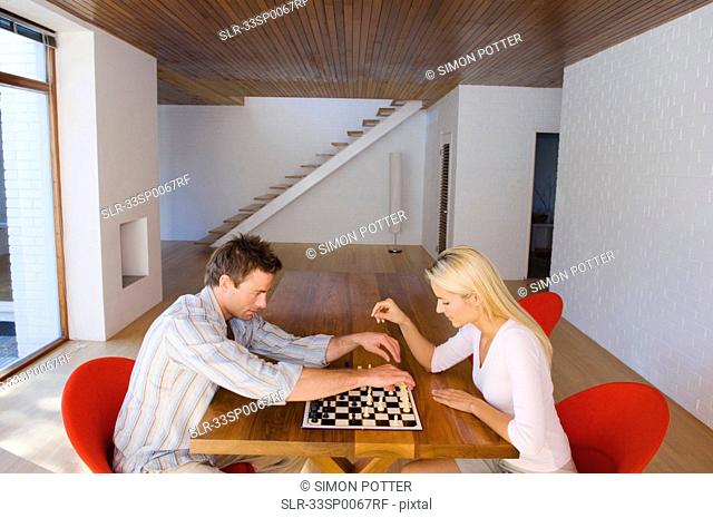 Couple playing chess together