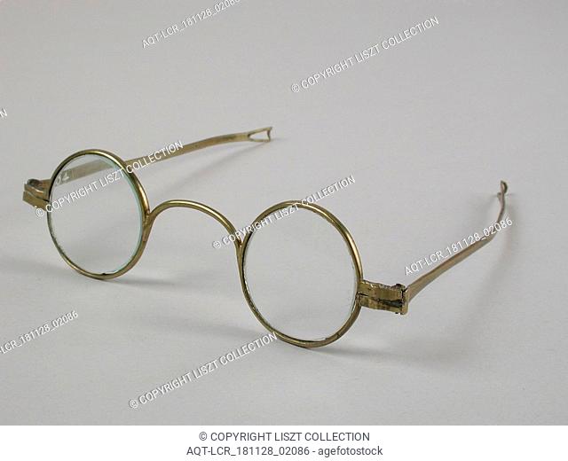 Glasses with round lenses on strength, frame of brass with wide bridge and hinged springs that end in loop shape, spectacle eye lens equipment glass copper base...