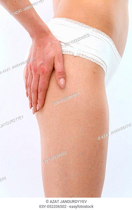 side view . a slender young sports girl in white underwear shows her figure, lifts her buttocks. isolated on a light background. without retouching.