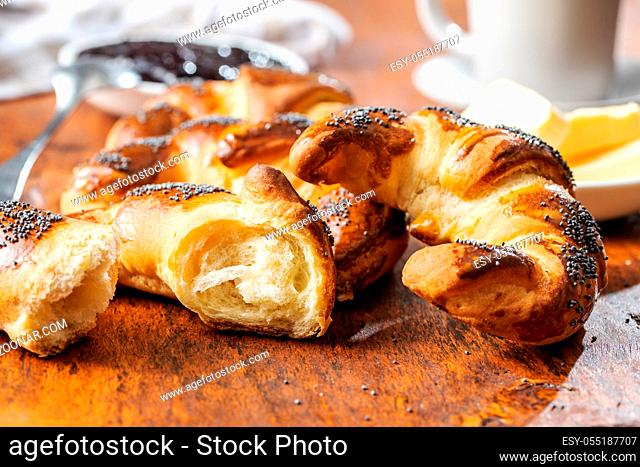 Sweet homemade croissants with poppy on wooden table