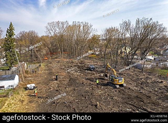 Detroit, Michigan - Workers clear trees from an abandoned railroad right of way that will be part of the Joe Lewis Greenway, a 27