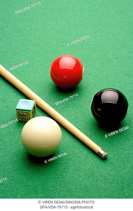 Snooker balls, cue chalk on table