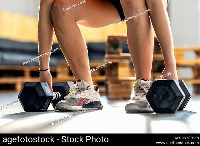 Athlete exercising with dumbbells in gym