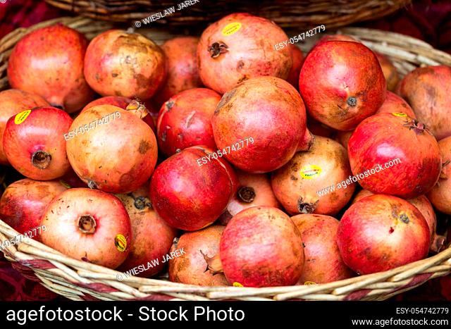 Group of fresh ripe pomegranate fruits in basket on display at local market