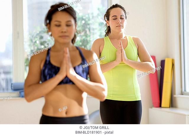 Women practicing yoga in studio
